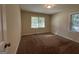 Spacious bedroom with neutral walls and carpet, featuring two windows with blinds and a door at 4778 Glenwood Rd, Decatur, GA 30035