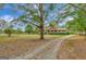 Ranch house with a long driveway and tree-lined landscape at 115 Bernhard Rd, Fayetteville, GA 30215