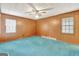 Bright bedroom with wood paneling and teal carpet at 115 Bernhard Rd, Fayetteville, GA 30215