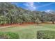 Open field with mature trees and a gravel road at 115 Bernhard Rd, Fayetteville, GA 30215