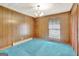 Spacious bedroom with wood paneling and teal carpet at 115 Bernhard Rd, Fayetteville, GA 30215