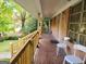 Wooden porch with railing, tiled flooring, and chairs, overlooking the front yard and street at 1723 Fort Valley Sw Dr, Atlanta, GA 30311