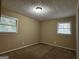 Bright bedroom with neutral walls, carpet, and two windows at 2929 Stratford Mill Rd, Lithonia, GA 30038