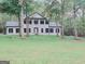 Two story home with white brick exterior, black shutters, and a manicured lawn at 275 Allie Dr, Mcdonough, GA 30252