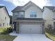 Two-story home with neutral brick and siding, two-car garage, and landscaping at 2299 Church St, Hampton, GA 30228