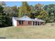 Brick ranch house with a covered porch and a grassy yard at 138 Michelle Dr, Mcdonough, GA 30252