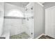 Elegant shower with marble tile, pebble floor, and glass enclosure at 1120 Strath Clyde Way, Mcdonough, GA 30253