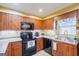 Kitchen with wood cabinets, black appliances, and granite countertops at 312 Brittany Ct, Duluth, GA 30096