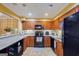 Kitchen with wood cabinets, black appliances, and granite countertops at 312 Brittany Ct, Duluth, GA 30096