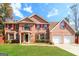 Two-story brick home with red shutters, large windows and a two-car garage at 2124 Hairston Creek Pkwy, Decatur, GA 30035