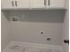 Laundry room with white cabinets and marble-look tile floor at 1540 Ox Bridge Ct, Lawrenceville, GA 30043