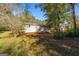 Rear view of tan house with a large yard and trees at 465 Haynie Rd, Moreland, GA 30259