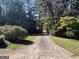 Driveway with lush green landscaping on either side at 1500 Pine Forest Rd, Mansfield, GA 30055