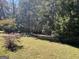 Wooded backyard with grassy area and trees at 1500 Pine Forest Rd, Mansfield, GA 30055