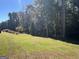 Spacious backyard with tall trees and green grass at 1500 Pine Forest Rd, Mansfield, GA 30055