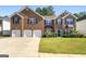Brick two-story house with three-car garage and landscaped lawn at 326 Cog Hill Dr, Fairburn, GA 30213