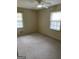 Well-lit bedroom with two windows, carpet flooring, and a ceiling fan at 554 Forest Hill Dr, Stockbridge, GA 30281