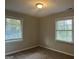 Spacious bedroom with neutral walls, plush carpeting, and two windows at 2190 Westover Dr, East Point, GA 30344