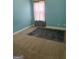 Vacant bedroom with teal walls, a window, and carpeted flooring at 1406 Stone Ridge Ct, Hampton, GA 30228