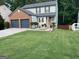 Two-story brick home with a two-car garage and landscaped lawn at 1004 Alford Ct, Lithonia, GA 30058