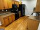 Kitchen with hardwood floors, wooden cabinets and black appliances at 1004 Alford Ct, Lithonia, GA 30058