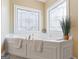 Relaxing bathroom featuring a corner soaking tub and stained glass windows at 2202 Escalade Ct, Conyers, GA 30094