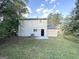 Light-grey house back with a small patio and yard at 6235 Creekford Ln, Lithonia, GA 30058