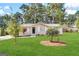 Newly renovated ranch home with a landscaped lawn and mature trees at 7125 Rhodes St, Lithonia, GA 30058
