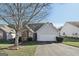 Gray house with a brick chimney and attached garage, nice landscaping at 1128 Strath Clyde Way, Mcdonough, GA 30253