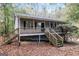 Front view of gray house with wooden stairs and deck at 215 Shadow Wood Dr, Douglasville, GA 30134