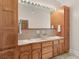 Double vanity bathroom with wood cabinets and large mirror at 32 Peeksville Rd, Locust Grove, GA 30248