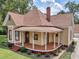 Cute yellow house with wrap-around porch and mature landscaping at 32 Peeksville Rd, Locust Grove, GA 30248