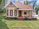 Charming yellow house with wrap-around porch and red trim at 32 Peeksville Rd, Locust Grove, GA 30248