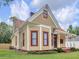 Yellow house with wrap-around porch, red trim, and mature landscaping at 32 Peeksville Rd, Locust Grove, GA 30248