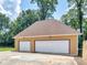 Two-car detached garage with white doors and light brown exterior at 32 Peeksville Rd, Locust Grove, GA 30248