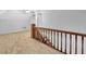 Upper level landing featuring a wooden railing and carpet flooring at 32 Peeksville Rd, Locust Grove, GA 30248