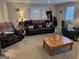 Living room with leather furniture, a wooden coffee table, and carpeted floors at 116 Winthrop Dr, Sharpsburg, GA 30277
