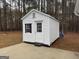 White shed with black trim and a concrete foundation in a backyard setting at 116 Winthrop Dr, Sharpsburg, GA 30277