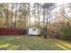 Small shed in backyard surrounded by trees and a wooden fence at 175 Jennifer Ln, Carrollton, GA 30116