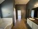 Bathroom with tub, double vanity, and dark-colored walls at 1529 Evergreen Hollow Ln, Conyers, GA 30012