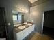 Bathroom with double vanity, large mirror, and garden tub at 1529 Evergreen Hollow Ln, Conyers, GA 30012