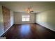 Living room with hardwood floors, exposed brick, and ceiling fan at 1529 Evergreen Hollow Ln, Conyers, GA 30012