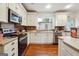 Kitchen with white cabinets, stainless steel appliances, and brick backsplash at 331 North Ave, Villa Rica, GA 30180