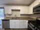 White kitchen cabinets, granite countertops, and stainless steel appliances at 4906 Springbrook Dr, Douglasville, GA 30135