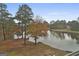 Peaceful backyard view of a lake with mature trees and landscaping at 12021 Scottish Ct, Fayetteville, GA 30215