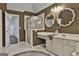 Bathroom with double sinks, a shower, and dark brown walls at 12021 Scottish Ct, Fayetteville, GA 30215