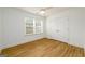 Empty bedroom with wood-look flooring, white walls, double closet doors, and windows at 79 Turner Dr, Mcdonough, GA 30252