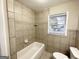 Simple bathroom with shower/tub combo and neutral tile at 8406 Norris Lake Rd, Snellville, GA 30039