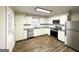 Updated kitchen featuring white cabinets, stainless steel appliances and LVP flooring at 8406 Norris Lake Rd, Snellville, GA 30039