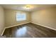 Bright bedroom featuring wood-look floors and a window with blinds at 55 Stone Creek Dr, Covington, GA 30016